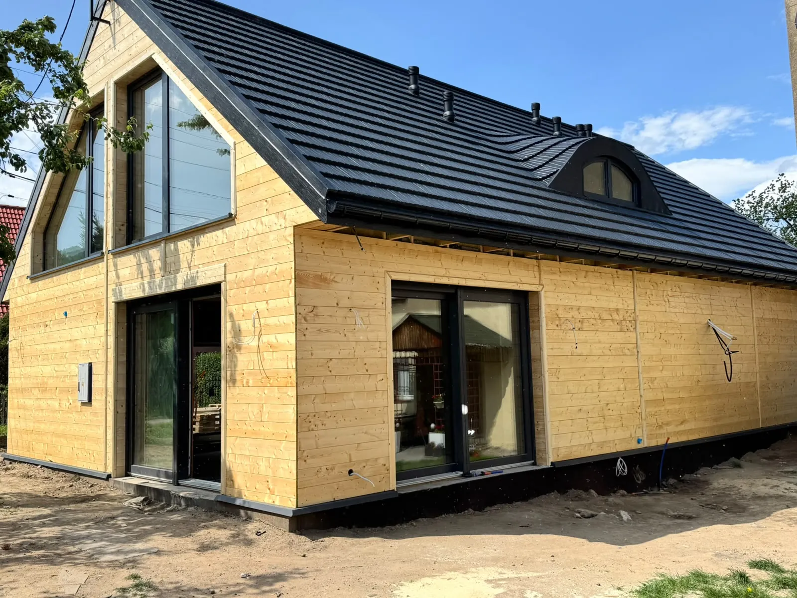 Dom z elewacją z naturalnego drewna i antracytowym dachem — realizacja STEGA